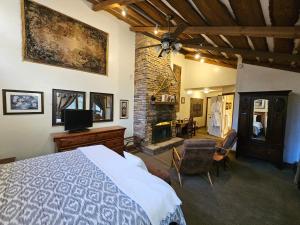 a bedroom with a bed and a stone fireplace at Inn at Lake Joseph in Forestburgh