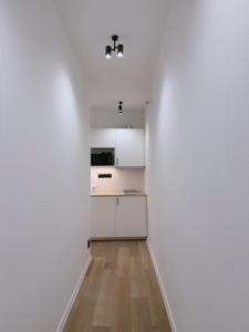 a kitchen with white walls and wooden floors at Milada 7 Suits in Brno +15 photos