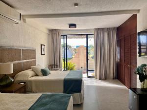 a bedroom with two beds and a large window at Hotel Boutique Casa Ceibas in Cuautla Morelos +60 photos