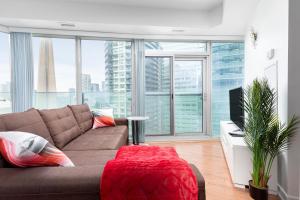 a living room with a couch and a large window at Downtown Toronto CN tower Condo in Toronto