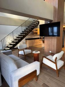 a living room with a couch and a staircase at Cayalá Hospitalidad in Guatemala