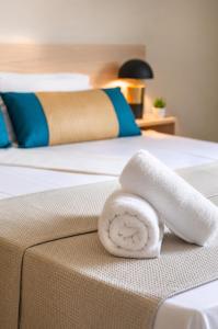 a white towel sitting on the edge of a bed at Sole e Mare B1 Beachfront Sea View Apartment in Koutsourás