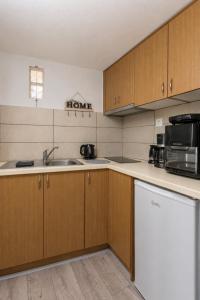 a kitchen with a sink and a microwave at Sole e Mare B1 Beachfront Sea View Apartment in Koutsourás +11 photos