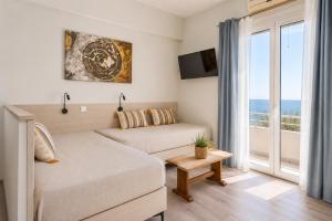 a living room with a couch and a window at Sole e Mare B1 Beachfront Sea View Apartment in Koutsourás