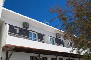 a white building with a balcony on top of it at Sole e Mare B1 Beachfront Sea View Apartment in Koutsourás