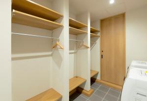a laundry room with wooden shelves and a washer and dryer at Rose - Rusutsu Chalets in Kimobetsu +41 photos