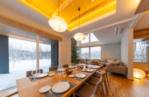 a dining room with a long table and chairs at Rose - Rusutsu Chalets in Kimobetsu