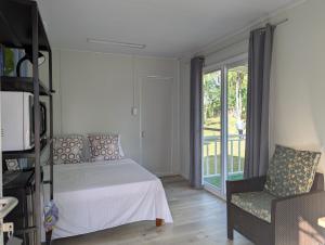 a bedroom with a bed and a chair and a window at AsunEus Farm in Carmen