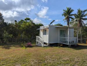 a small white house with a porch on a yard at AsunEus Farm in Carmen