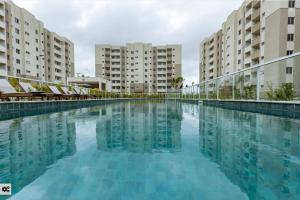 a large swimming pool with buildings in the background at Apto com ar e piscina próximo a Cabo Frio e Arraial do Cabo in São Pedro da Aldeia
