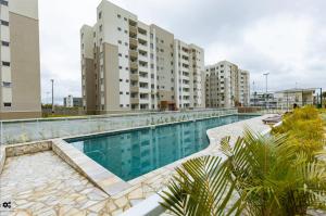 a swimming pool in a building with tall buildings at Apto com ar e piscina próximo a Cabo Frio e Arraial do Cabo in São Pedro da Aldeia