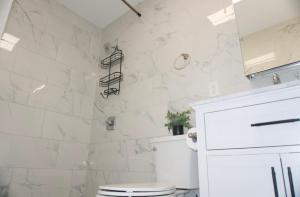 a white bathroom with a toilet and a shower at New York view 37 in West New York