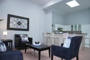 a living room with chairs and a table and a kitchen at New York view 37 in West New York