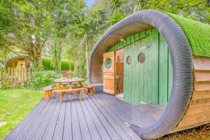 a wooden deck with a table and a green building at 1 Bed in Bude oc-s34857 in Bude +18 photos