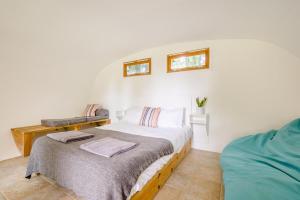 a white bedroom with a bed and two windows at 1 Bed in Bude oc-s34858 in Bude