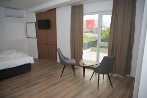 a bedroom with a bed and a table and chairs at DION Hotel & Restaurant in Kumanovo