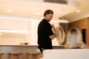 a man standing in a room dyeing a persons hair at Esprit Holidays Rainbow Bay in Gold Coast +287 photos
