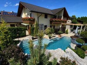 a swimming pool in front of a house at AlpenAppartement Traumzeit in Bernau am Chiemsee