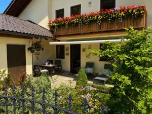 a house with a balcony with flowers on it at AlpenAppartement Traumzeit in Bernau am Chiemsee