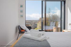a bedroom with a bed and a chair and a window at Little Spinney in Dorchester