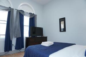 a bedroom with a bed and a tv on a dresser at New York view 38 in West New York