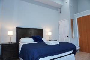 a bedroom with a bed with a blue blanket and two lamps at New York view 38 in West New York