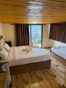 a bedroom with two beds and a large window at Dana in Tufailah