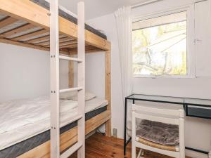 a bedroom with two bunk beds and a desk at 4 star holiday home in Græsted in Græsted