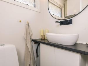 a bathroom with a white sink and a mirror at 4 star holiday home in Græsted in Græsted +24 photos