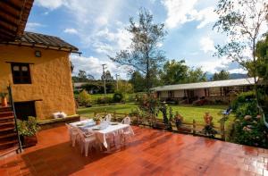 a patio with white tables and chairs on a brick floor at Hotel la Mana Nobsa in Nobsa