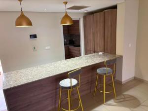 a kitchen with two bar stools and two lights at Waterfront - B luxury in Dakar