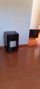 a microwave oven sitting on top of a wooden floor at Luci Alojamiento in Uspallata