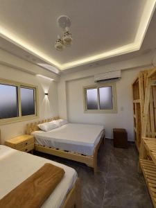 a bedroom with two beds and windows at Villa solla in Dahab