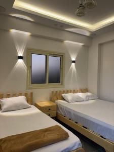 two beds in a room with two windows at Villa solla in Dahab