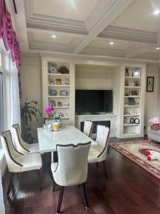a dining room with a table and chairs and a television at Vancouver lovely home in Vancouver