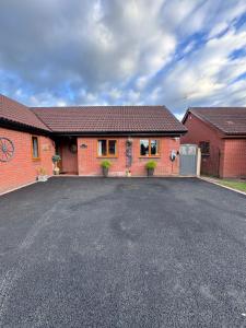 a brick house with a driveway in front of it at Pentre Country Studio in Wrexham