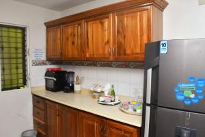 a kitchen with wooden cabinets and a stainless steel refrigerator at Vacacional rent in Boca Chica +3 photos
