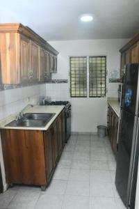 a kitchen with a sink and a refrigerator at Vacacional rent in Boca Chica