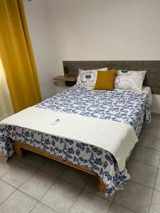 a bed with a blue and white blanket on it at Vacacional rent in Boca Chica