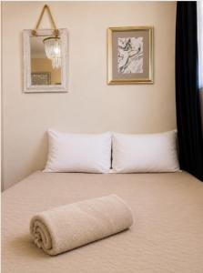 a bed with white pillows and a towel on it at Dalia Room, Paseo Durango in Durango