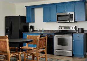 a kitchen with blue cabinets and a table and chairs at Starfish Manor Oceanfront Hotel in Lincoln City
