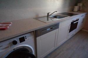 a kitchen with a sink and a washing machine at Haus Alpenblick inkl. Chiemgaukarte in Ruhpolding