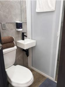a bathroom with a white toilet and a sink at Dalia Room, Paseo Durango in Durango