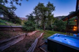 a hot tub in a yard next to a house at Hygge Haus Sequoia - Large Private Cabin w Views in Ponderosa