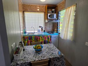 a kitchen with a table with a bowl of bananas on it at Bora Bora Vairupe lodge in Bora Bora