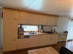 a kitchen with white cabinets and a sink at Chalet Makkum V10 in Makkum