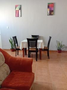 a living room with a table and chairs and a couch at Departamento ANSOPH in Ilo