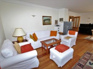 a living room with white furniture and a piano at Almenblick in Kleblach