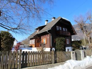 a house behind a fence in the snow at Almenblick in Kleblach