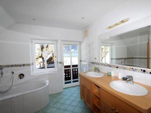 a bathroom with two sinks and a bath tub and a tub at Almenblick in Kleblach +16 photos